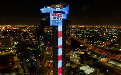 Largest Electronic U.S. Flag & L.E.D. “VOTE” Lapel Button Image Illuminate Paramount Miami